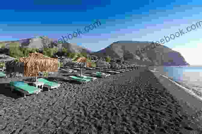 A Serene Image Of Perissa Beach, Depicting Its Black Volcanic Sand, Crystal Clear Waters, And The Imposing Backdrop Of Mesa Vouno Top 10 Things To See And Do In Santorini Top 10 Santorini Travel Guide (Europe Travel 35)